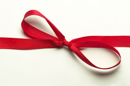 Red gift celebration ribbon bow over white background