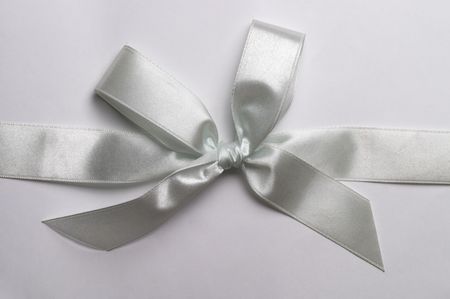 White gift celebration ribbon bow over grey backgroundの写真素材