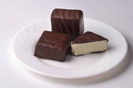 Souffle chocolate candies on the white porcelain plate isolated over grey backgroundの写真素材