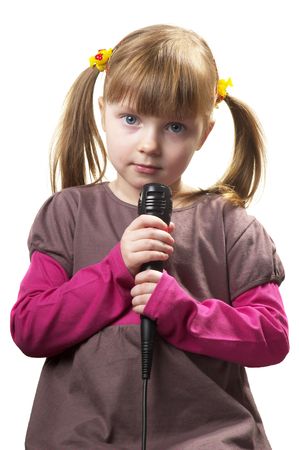 Funny little girl singing with microphone isolated over white backgroundの写真素材