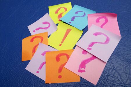 Sticker notes with exclamation and question signs over blue leather backgroundの写真素材