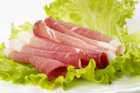 Jamon ham slices over leafs of lettuce macro shotの写真素材