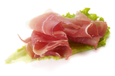 Jamon ham slices over leafs of lettuce macro shotの写真素材