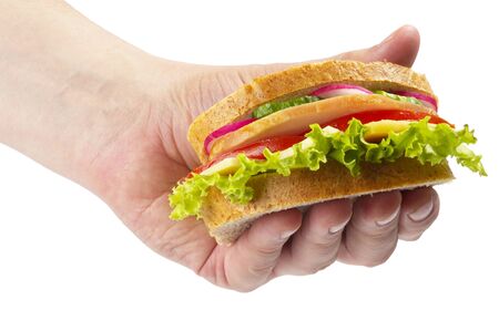 Sandwich with ham, tomato, radish, cucumber and cheese in the hand isolated over white backgroundの写真素材