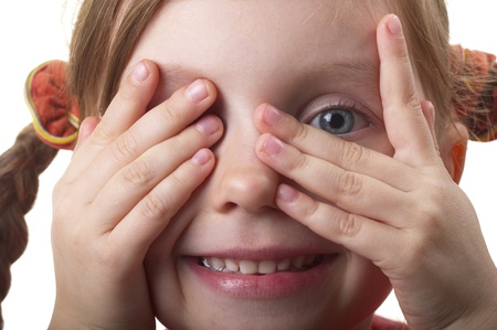 Little girl peeping through hand with one eye isolated over white backgroundの写真素材