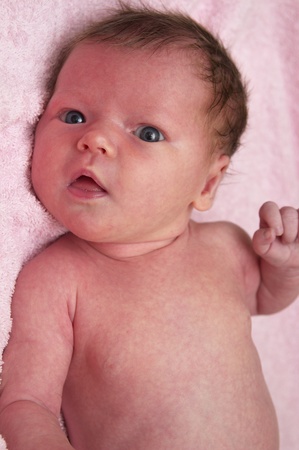 Newborn baby girl over soft pink towelの写真素材