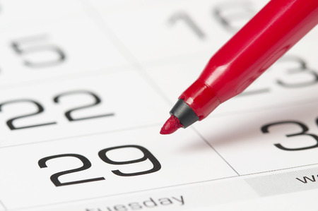 Red pen over slightly defocused calendar backgroundの写真素材