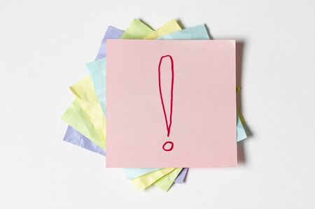 Sticker notes with exclamation sign over white backgroundの写真素材