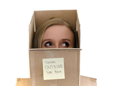 Models head popping out of the box with the sign  Think outside the box  on itの写真素材