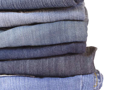 stack of folded jeans on white backgroundの写真素材
