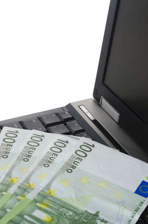 close up of a laptop computer with couple of euro notes on the keyboard vertically croppedの写真素材