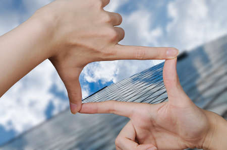 out of focus business building and fingers creating a square making the vision clearの写真素材