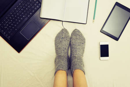 female legs wearing surrounded by multiple communication devicesの写真素材