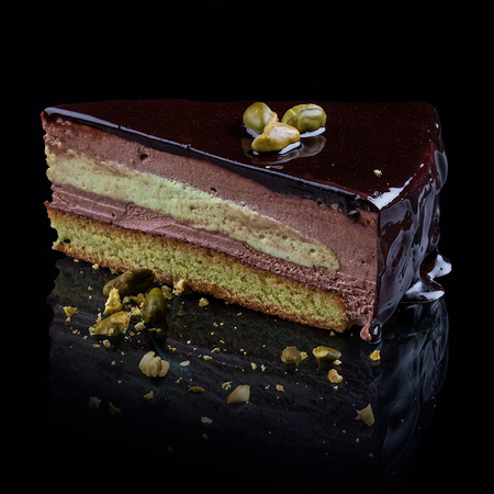 Pistachio biscuit with chocolate cream-mousse on a black backgroundの写真素材