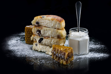 Cheese pancakes with a raisins on a black backgroundの写真素材