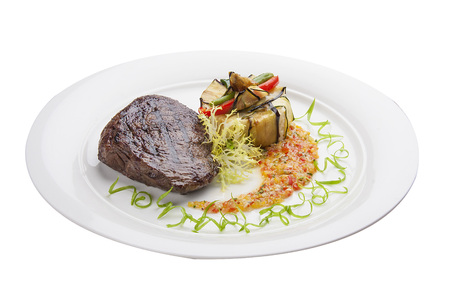 Veal steak with salsa on a white plateの写真素材