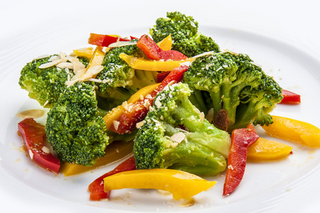Dietary broccoli with vegetables and peanuts. On a white plate.の写真素材