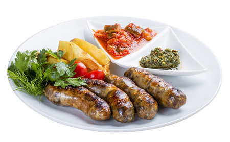 Homemade sausages with potatoes and sauce. On a white plateの写真素材