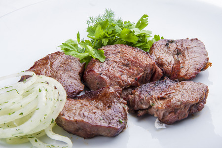 Veal shashlik with onion on a white plateの写真素材