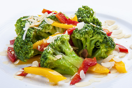 Dietary broccoli with vegetables and peanuts. On a white plate.の写真素材