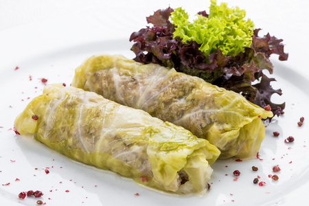 Rolls of cabbage with meat and vegetables on a white plateの写真素材