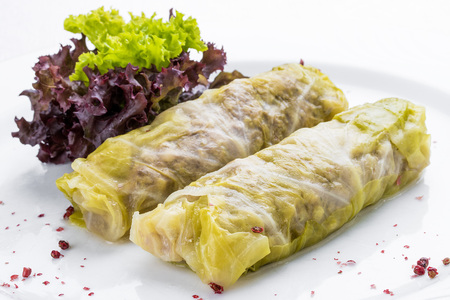 Rolls of cabbage with meat and vegetables on a white plateの写真素材