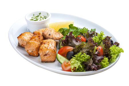 Shish kebab from salmon with vegetables and salad. On a white plateの写真素材