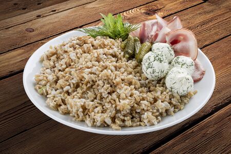 Pearl barley with ham and cheese balls. On a wooden backgroundの写真素材