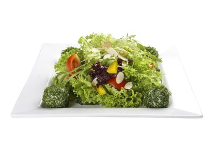 Salad with vegetables and cheese balls on a white plateの写真素材