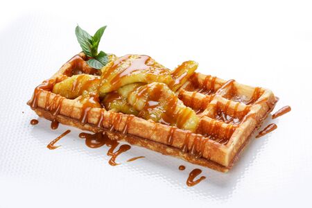 Belgian sweet waffles on a white background. Stuffed with apples, caramel syrup underの写真素材