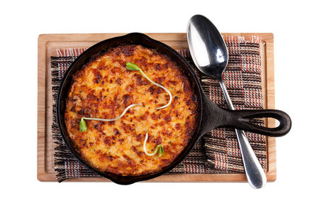 Lasagna in a cast iron pan. The view from the top. On white background