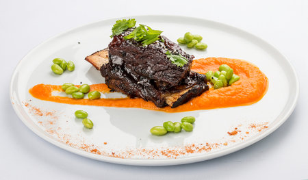 Pork rib with sauce on a white plate