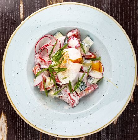 Vegetable salad of radish, cucumber and tomato with poached egg.の写真素材