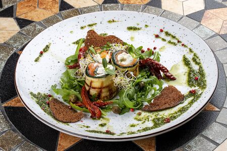 Eggplant rolls with salmon and Philadelphia cheese. With Arugula and sun-dried tomatoesの写真素材