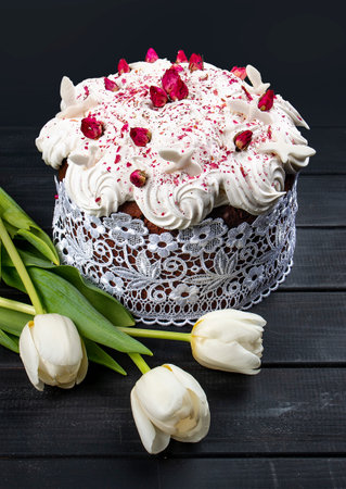 Easter composition with orthodox sweet bread, kulich and eggs on dark background.