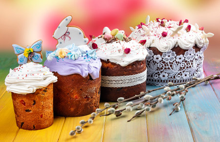 Various Spring Easter cakes with white icing and sugar decor on the table decorated in rustic style