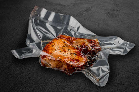 Vacuum-packed grilled meat, on a dark background. Set of different types of meat. Ready to eat.の写真素材