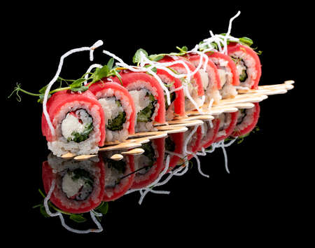 Philadelphia roll with tuna on glossy black backgroundの写真素材