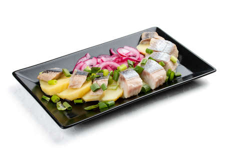 Appetizer with lightly salted herring, boiled potatoes and onions. Isolated on a white backgroundの写真素材