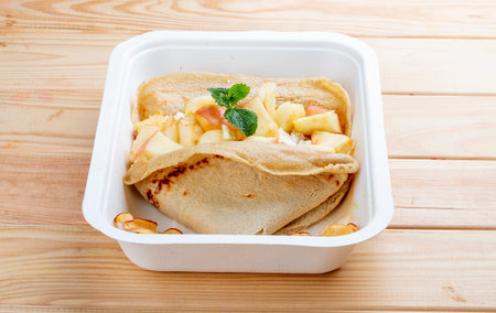 Oatmeal pancake with cottage cheese and spiced apples. Healthy food. Takeaway food. On a wooden...