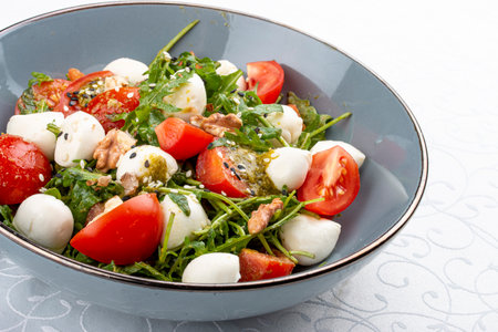 Caprese salad, cherry tomatoes, mozzarella, arugula and pesto sauce. Isolated imageの写真素材