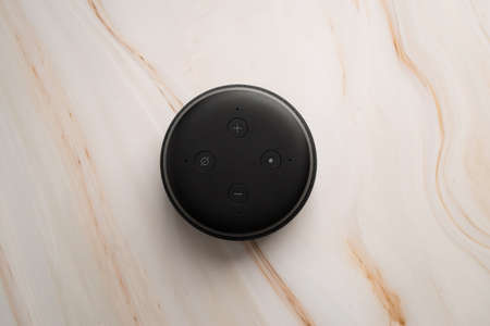 LONDON, UNITED KINGDOM - SEPTEMBER 20 2020: Close-up of an Amazon Echo Dot, the virtual assistant speaker, with a modern marble background.のeditorial素材