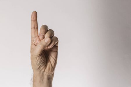Man`s hand gesture, counting number one, isolated on whiteの写真素材