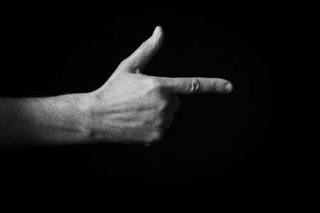 Dramatic black and white image of Backhand Index Pointing Right emoji isolated on black backgroundの写真素材