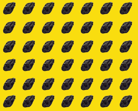 Black prunes on a yellow background