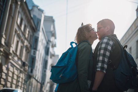A young couple of lovers are walking around the city, kissing. Newlyweds on a honeymoon trip.
