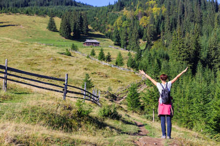 Girl with her hands up on the background of the mountainsの写真素材