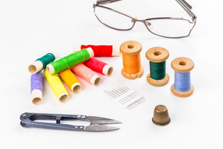Colored thread with scissors on white background