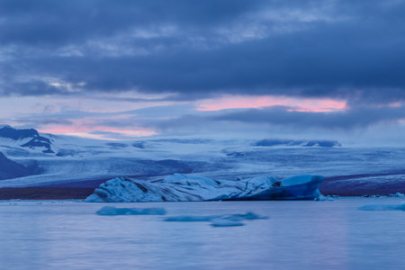 Icebergs floating in Fjallsarlon glacier lake at sunset. South Iceland.Close to Jokulsarlon lagoon./...