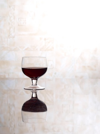 Color photo of a glass of red wine glasses on mirror surface      の写真素材